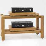 Kunsst rack for audio equipment with a hi-fi amplifier on the top shelf and a CD player on the lower shelf, standing on a white background.