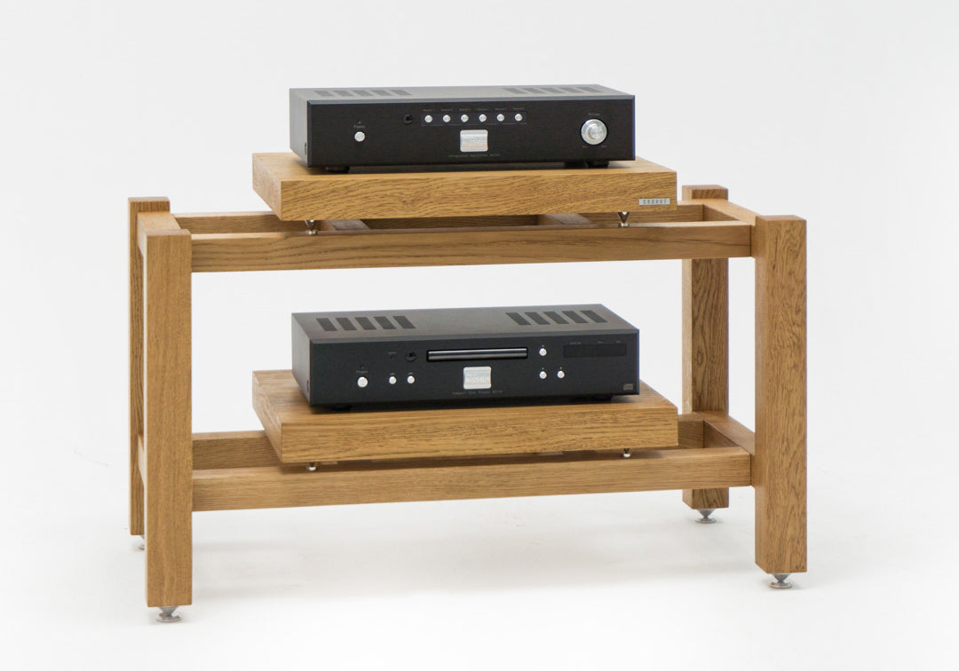 Kunsst rack for audio equipment with a hi-fi amplifier on the top shelf and a CD player on the lower shelf, standing on a white background.