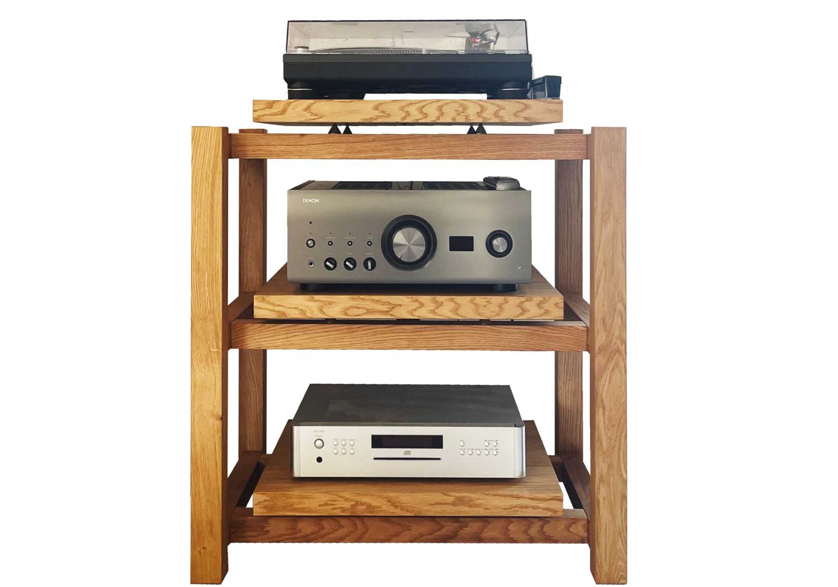 Handmade wooden audio rack for hifi amplifier and turntable on the top shelf, a Denon amplifier below, and a Rotel RCD-1572 CD player on the lowest platform, forming a minimalist audiophile setup photographed against a plain background.
