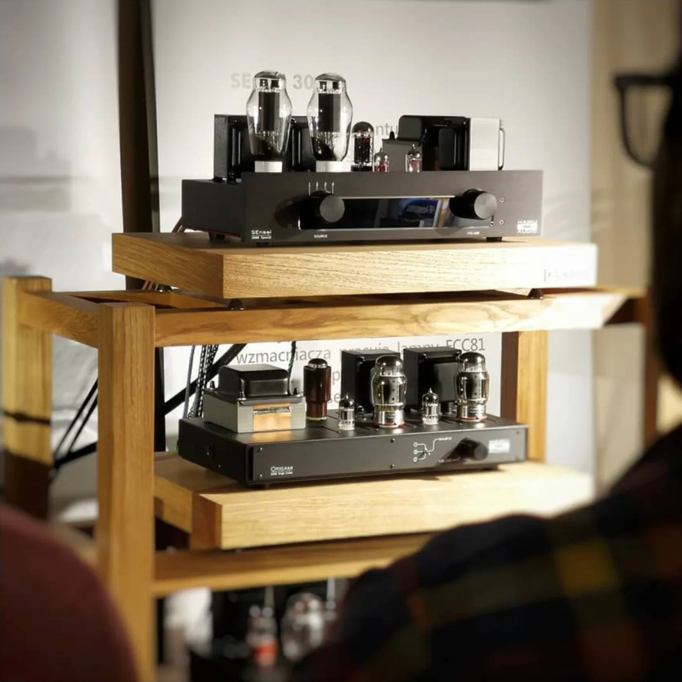 Wooden hifi stand with audio equipment including tube amplifiers standing in audiophile room
