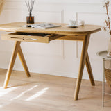 Kunsst vintage desk for a vanity with smooth rounded edges is showcased in a bright, luxury living room with elegant mouldings and decorative items. A magazine and a cup of coffee are placed on the solid wood desk top.