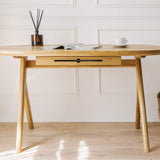 Kunsst solid wood desk with drawer is showcased in a classic office on natural wood flooring, backed by a white wall with elegant mouldings. 