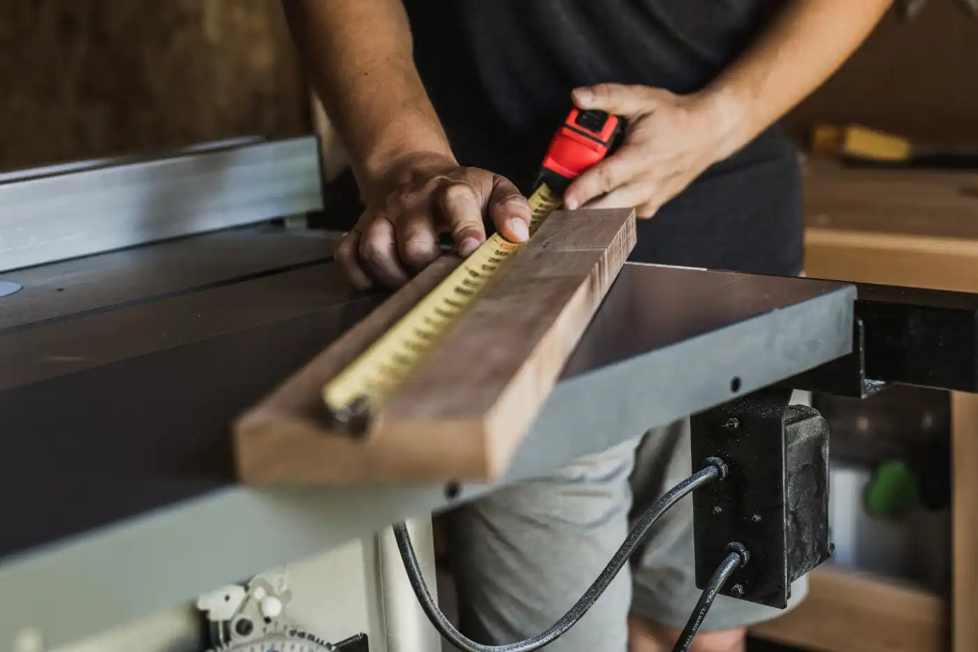 Person using a table saw to cut a piece of wood.
