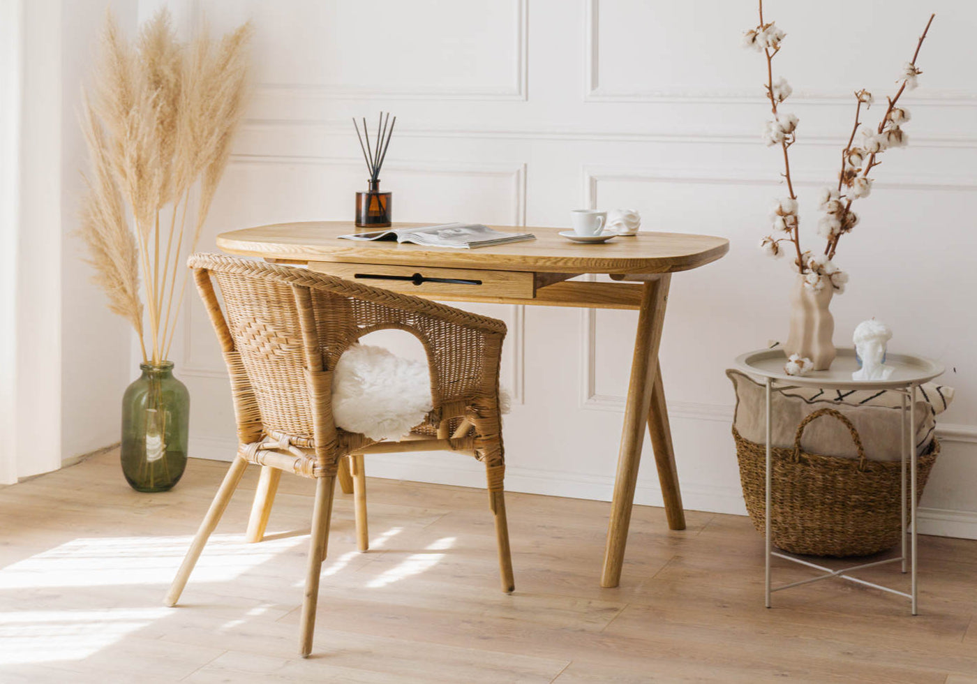 Elegant solid wood vintage desk for a vanity with wicker chair and decorative items, standing on a wooden floor in a classic style room with wall mouldings.