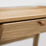 Detail of oak grain on wood desk with drawers and leather handle standing on a white background 